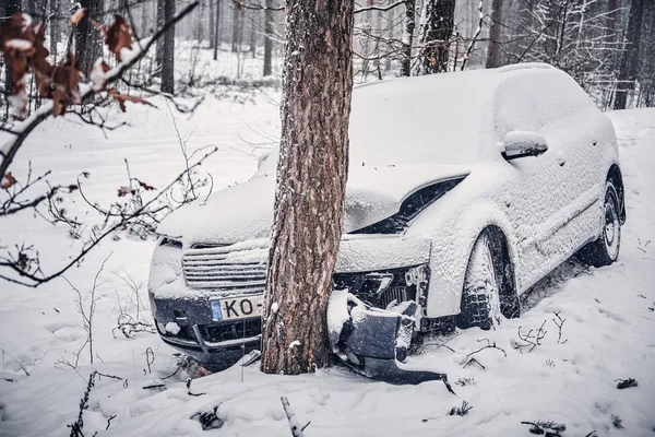 Bilen hamnade i en skid och kraschade in i ett träd på en snöig väg. — Stockfoto