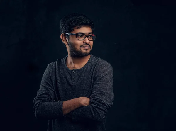 Studio portret van een jonge Indiase kerel dragen brillen en casual kleding, poserend met zijn armen gekruist en zijwaarts op zoek — Stockfoto