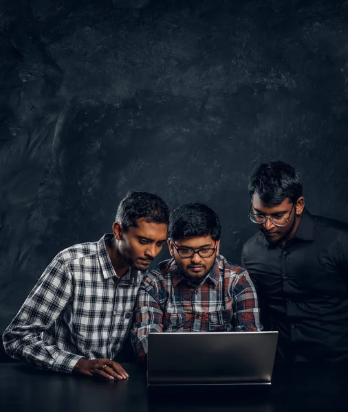 Bir dizüstü bilgisayar ile masada bekleyen birlikte bir proje üzerinde çalışan üç Hint öğrenciler — Stok fotoğraf