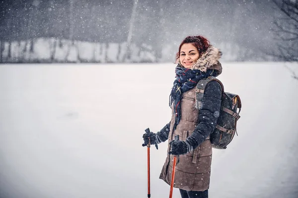 Porträt eines Mädchens mit Rucksack, das durch den Winterwald geht — Stockfoto