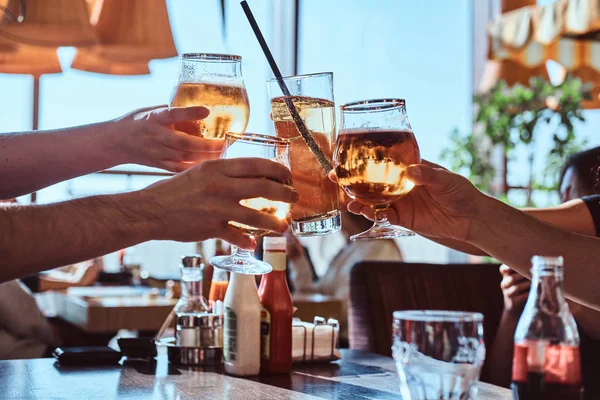 Freunde genießen ein Bier in einem Café im Freien, klirren mit Gläsern Bier gegen den klaren Himmel — Stockfoto