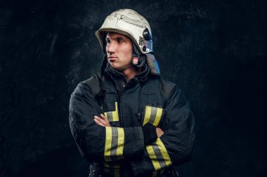 Kask içinde erkeksi itfaiyeci yana doğru görünüyor