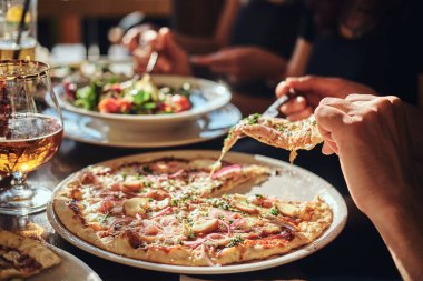 Genç arkadaşlar öğrenciler pizza ve salata içinde açık bir caf öğle yemeği molası sırasında yemek 