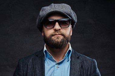 Yakın çekim giyen bir bere ve ceket, beyaz arka plan üzerinde izole güneş gözlüğü başarılı bir şık adam portresi