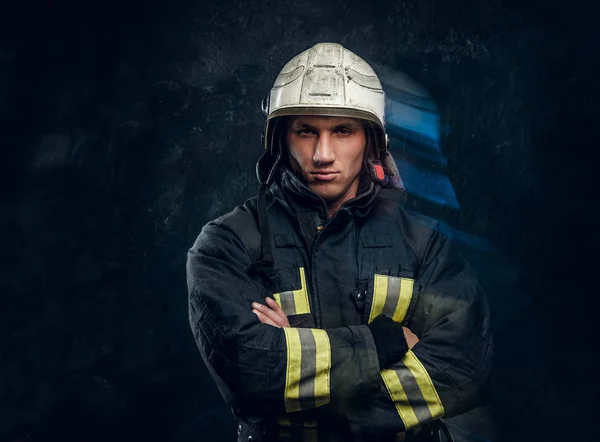 Brutal fireman in uniform posing for the camera standing with crossed arms and confident look. — Stock Photo, Image