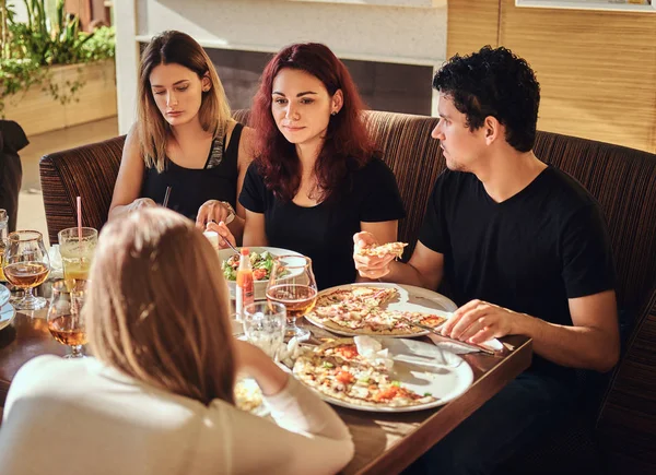 Hora de la pizza. Jóvenes amigos disfrutando de pizza y ensalada en un café al aire libre — Foto de Stock