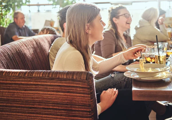 Unga vänner njuter av mat och ha roligt tillsammans i restaurang eller café utomhus — Stockfoto