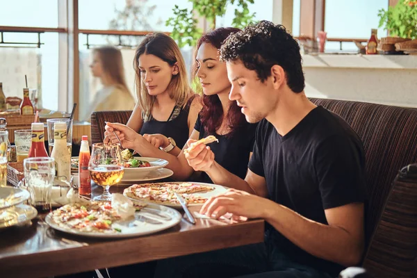 Hora de la pizza. Jóvenes amigos disfrutando de pizza y ensalada en un café al aire libre — Foto de Stock