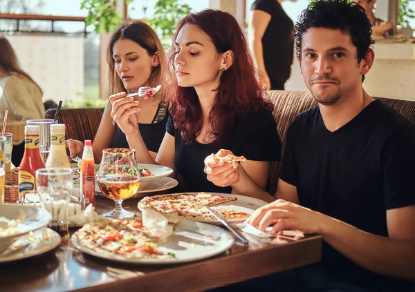 Hora de la pizza. Jóvenes amigos disfrutando de pizza y ensalada en un café al aire libre —  Fotos de Stock