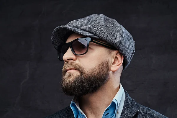 Close-up retrato de um homem elegante de sucesso em óculos de sol vestindo uma boina e jaqueta, isolado no fundo branco — Fotografia de Stock