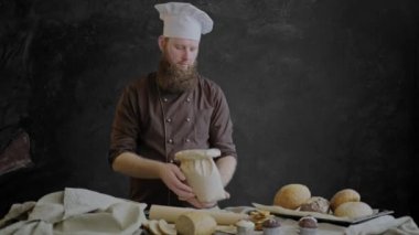 Şef onun ekmek hamur işleri ile dekore edilmiş bir tablo yakın duran un kalitesini denetler.