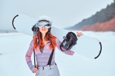 Bir güzel kızıl saçlı kız kış şapka ve gözlük poz portresi