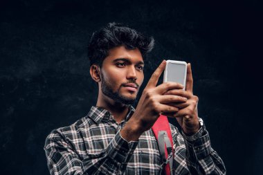 Bir smartphone kullanarak, arkadaşlarıyla sohbet sırt çantası ile yakışıklı Hint öğrenci.