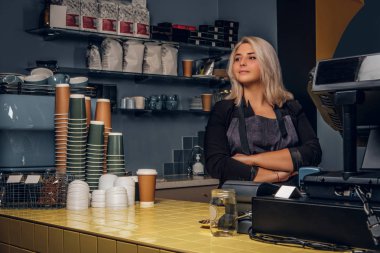Kadın barista çapraz kolları poz ve yana doğru bir kahve dükkanı veya kafe arıyorsunuz