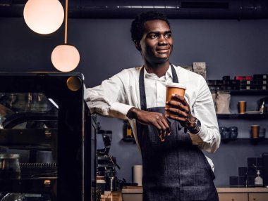 Bir fincan kahve ile bir kafede bir sayaçta eğilerek süre tutarak Afrika barista