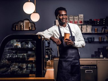 Bir fincan kahve ile bir kafede bir sayaçta eğilerek süre tutarak Afrika barista