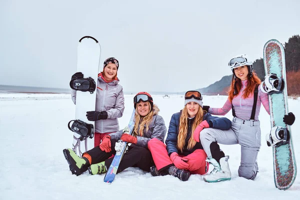 Χαρούμενα γυναίκες φίλους σε σπορ χειμερινά ρούχα με σνόουμπορντ και σκι αγκάλιασμα μαζί — Φωτογραφία Αρχείου