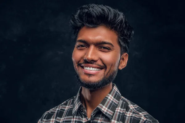 Närbild porträtt av en stilig indiska man som bär en rutig skjorta, leende och tittar på en kamera. — Stockfoto