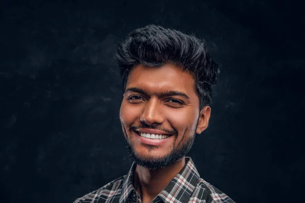 Close-up retrato de um belo indiano vestindo uma camisa xadrez, sorrindo e olhando para uma câmera . — Fotografia de Stock