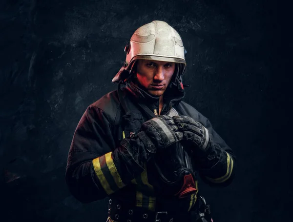 Manly firefighter in helmet looks into camera