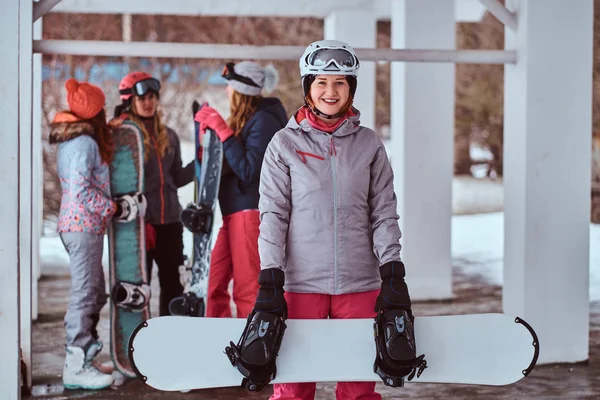 Pelirroja usando ropa deportiva de invierno posando con una tabla de snowboard —  Fotos de Stock