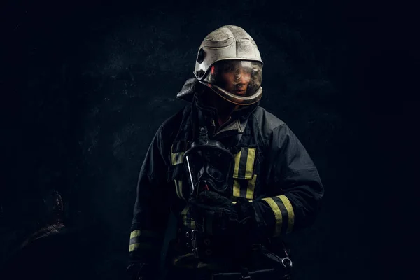 Мужественный пожарный в шлеме смотрит в сторону — стоковое фото