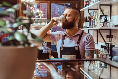 Barista kahve dükkanı sayacında arkasında, öğle yemeği molası sırasında kahve içme önlük