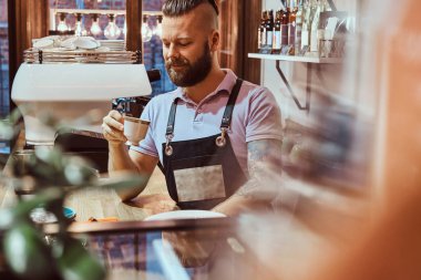 Barista kahve dükkanı sayacında arkasında, öğle yemeği molası sırasında kahve içme önlük