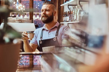 Barista kahve dükkanı sayacında arkasında, öğle yemeği molası sırasında kahve içme önlük