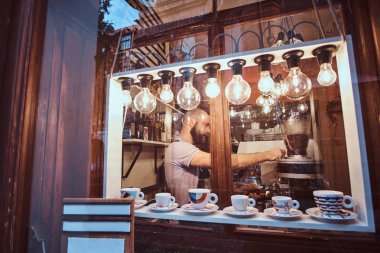 Görünümü dışında trendy bir kahve dükkanında çalışan barista adam