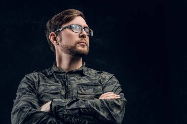 Kendinden emin bir hacker ile çapraz el poz ve yana doğru seyir şık bir askeri gömlek.