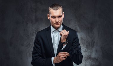 Karanlık Studio kolları üzerinde düğmeleri Tespitleme bir siyah Klasik takım elbise giymiş yakışıklı bir adam.