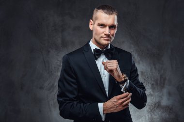 Siyah elbiseli düğmeleri kollu tespitleme yakışıklı bir adam.