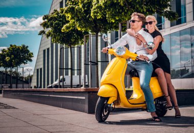 Romantik Çift bir klasik İtalyan scooter bir Avrupa şehri modern bir parçası sokakta oturan
