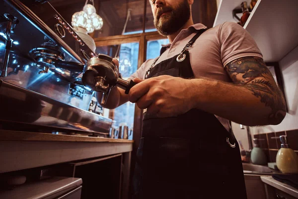 Foto de bajo ángulo de un barista sosteniendo un portafilter, trabajando en la cafetería —  Fotos de Stock