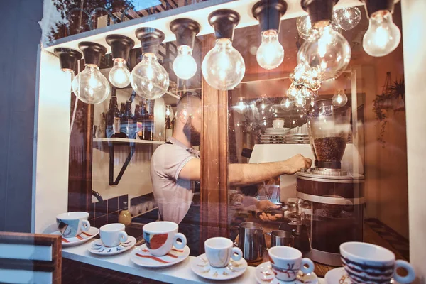 The barista working in a trendy coffee shop, outside view