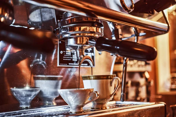 Eine Kaffeemaschine, die eine Tasse Kaffee im Restaurant eines Cafés zubereitet — Stockfoto