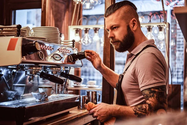 Barista en uniforme preparando una taza de café para un cliente en la cafetería — Foto de Stock