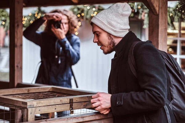 A young photographer and his friend walking around the city market — Stock Photo, Image