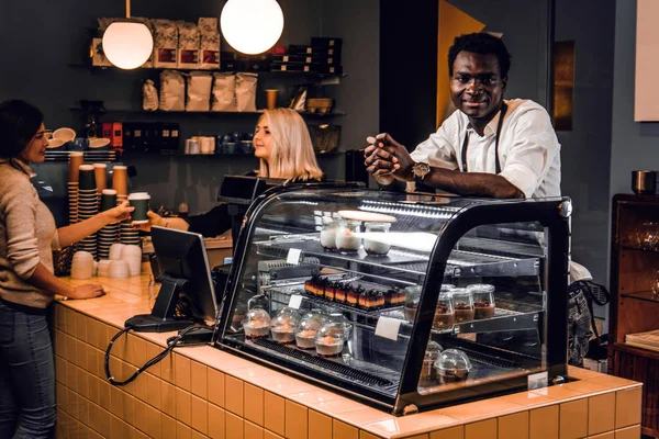 Dos jóvenes baristas trabajando en su cafetería de moda . —  Fotos de Stock