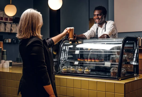 Barista africano da el cliente de café ordenado de la cafetería moderna —  Fotos de Stock