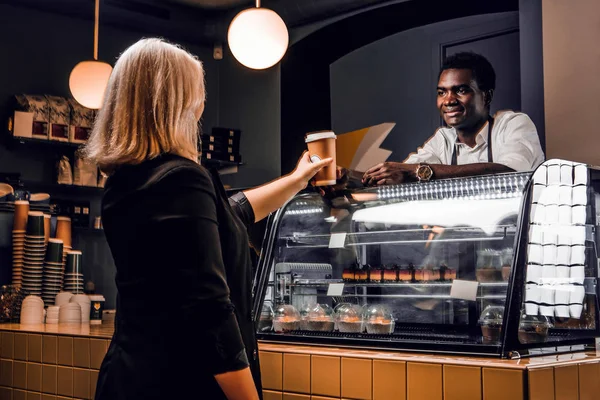 Barista africano da el cliente de café ordenado de la cafetería moderna —  Fotos de Stock
