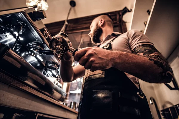 Foto de baixo ângulo de um barista segurando um portafilter, trabalhando na cafeteria — Fotografia de Stock