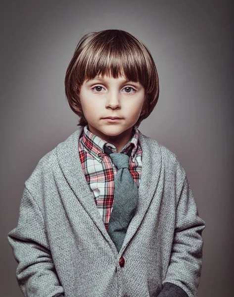 Porträtt av en söt kaukasiska skolpojke eleganta kläder håller händerna i fickorna — Stockfoto