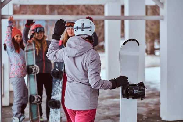 Πίσω όψη του ένας snowboarder γυναίκα κρατώντας ένα Διοικητικό Συμβούλιο — Φωτογραφία Αρχείου