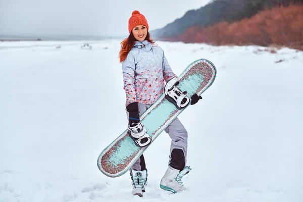 Mujer joven sosteniendo snowboard —  Fotos de Stock