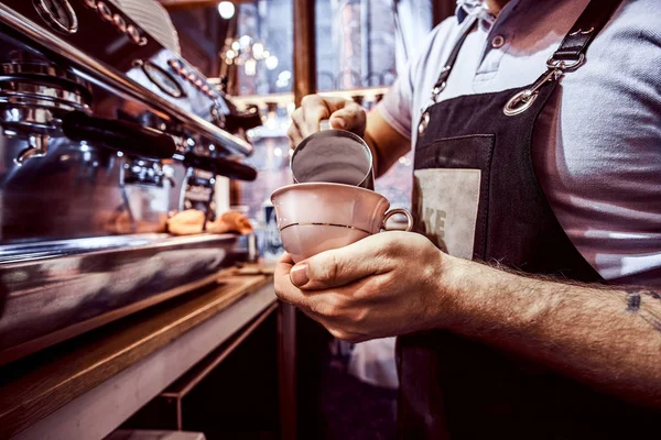 Barista usando delantal haciendo un capuchino, vertiendo leche en una taza en un restaurante o cafetería —  Fotos de Stock