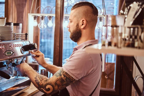 Barista en uniforme haciendo café para un cliente en la cafetería —  Fotos de Stock