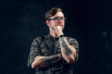 Dalgın dövmeli hipster sol görünüyor ve bir el çene yakın tutar