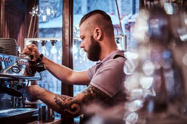 Dövmeli barista şık sakal ve saç modeli bir kafe ya da Restoran bir kahve makinesinde çalışma ile